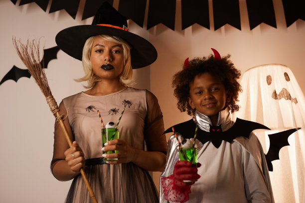 非洲裔美国母亲女巫和儿子魔鬼站在拍摄区与幽灵人体模型的肖像图片下载