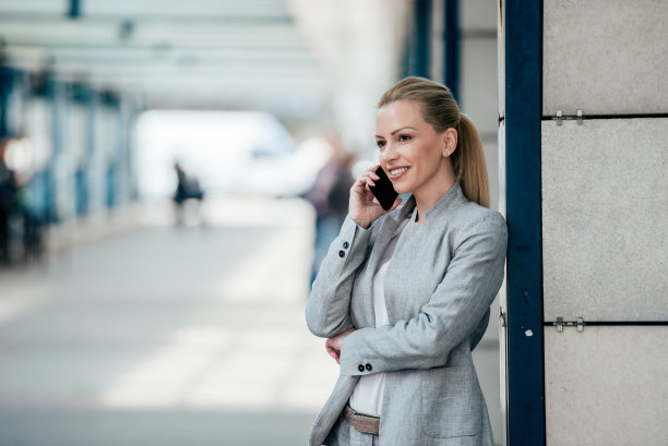 商业、技术和人的概念。美丽的女商人在城市中使用智能手机。图片下载