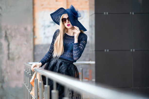 一个漂亮的年轻金发女人的肖像戴着帽子和太阳镜在户外图片下载