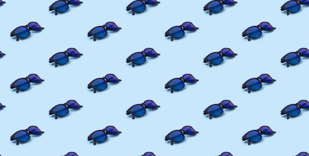 无缝模式与时尚的现代太阳镜在蓝色背景。图片下载