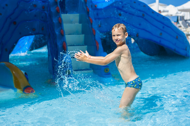 快乐的男孩，在水上公园的游泳池里放松图片下载