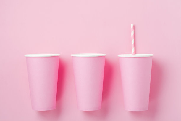 三个粉红色的纸杯咖啡在粉红色的纸光背景。“零浪费”的概念。平的。图片下载