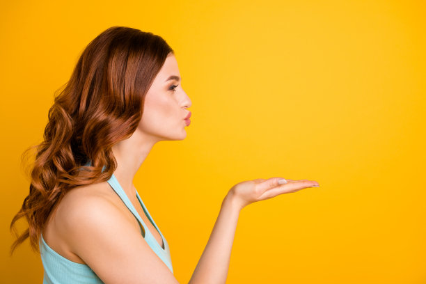 Copyspace照片姜狐狸迷人的美丽的迷人的可爱的漂亮的甜美的漂亮的女朋友送一个飞吻给某人穿与黄色鲜艳的背景孤立的蓝绿色背心图片下载