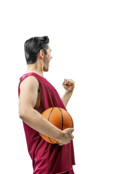 后视图亚洲男子篮球运动员抱着球与兴奋的表情图片下载