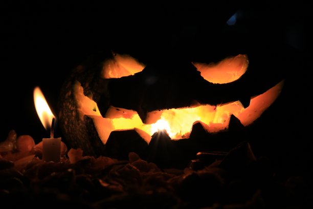 雕刻吓人的南瓜烛台里有一堆火，还有万圣节用的果核图片下载