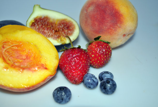 鲜亮多汁的新鲜水果和浆果。桃子，无花果，草莓，蓝莓图片下载