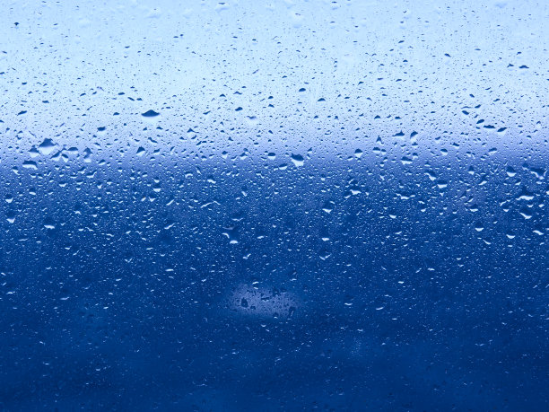 水珠落在窗玻璃上，玻璃后是大海和地平线。图片下载