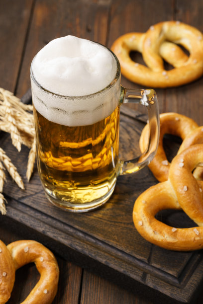 一大杯淡啤酒配德国椒盐卷饼。图片下载