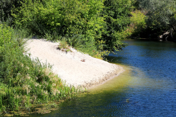 夏天天气晴朗时，在清澈的河流拐弯处有沙滩图片下载