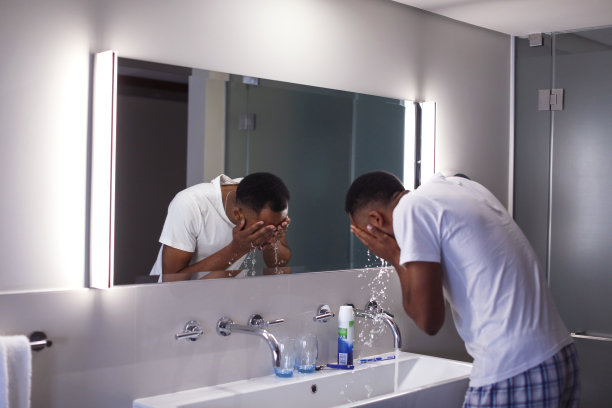 一个非洲人在酒店房间里洗脸。图片下载