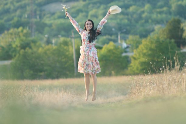 肖像快乐年轻的金发女人在一个阳光明媚的夏天在草地上跑步的股票照片图片下载