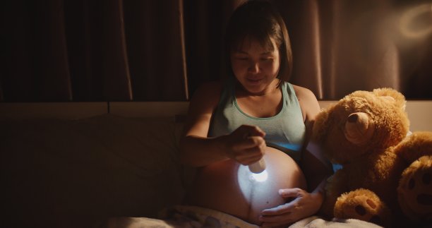 怀孕的母熊用手电筒和她未来的宝宝玩耍图片下载