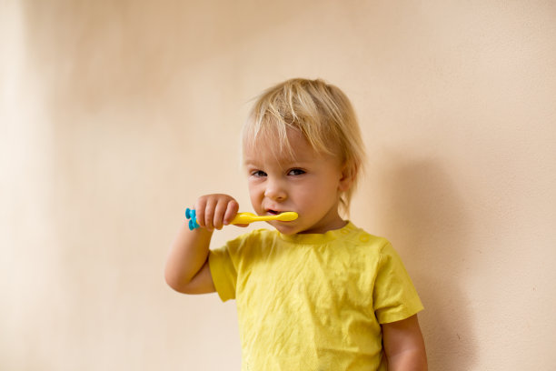 蹒跚学步的小男孩正在用牙刷刷牙图片下载