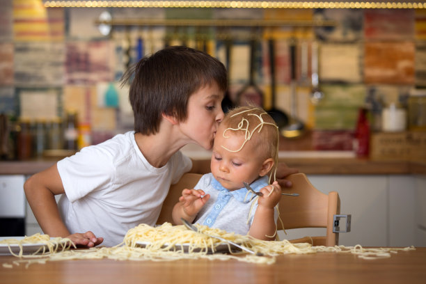 小男孩，蹒跚学步的孩子，午餐吃意大利面，弄得一团糟图片下载