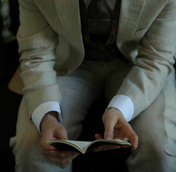 坐在沙发上看书的年轻男子图片下载