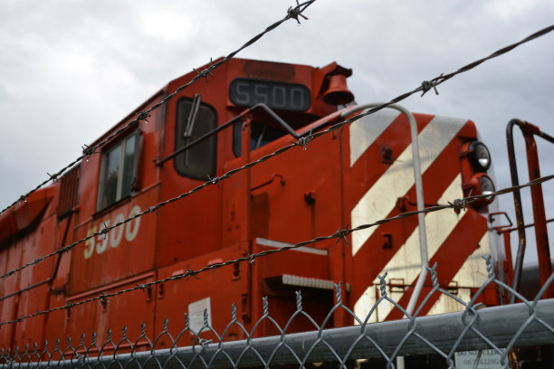 院子里有带刺的铁丝网和火车发动机图片下载