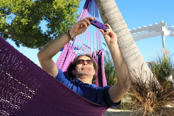 中年男子在吊床上放松自拍图片下载