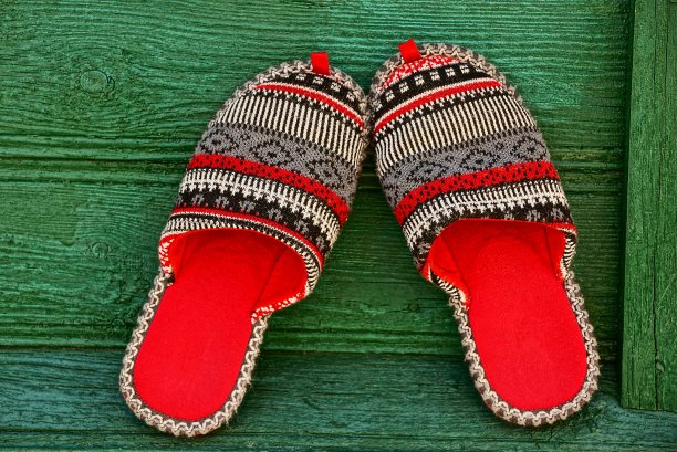 有图案的彩色拖鞋放在绿色的木板上图片下载