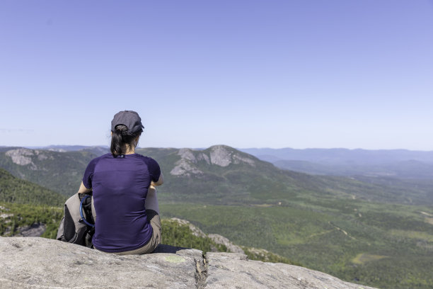 在加拿大魁北克省大花园国家公园徒步旅行后，一名妇女在山顶休息图片下载