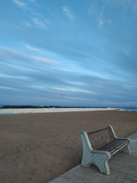 沙滩边的长椅，映衬着美丽的天空图片下载