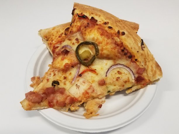 培根、火腿、胡椒和洋葱披萨放在白盘子里图片下载