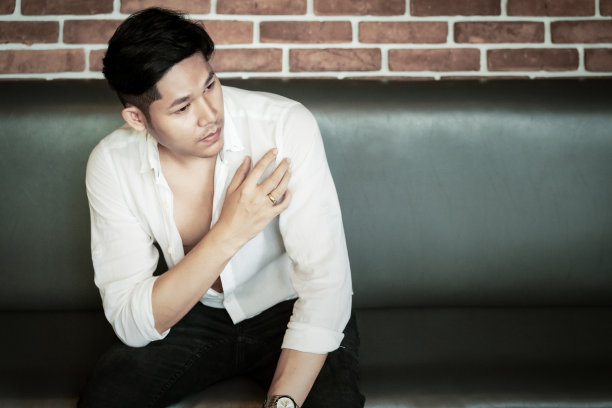 年轻英俊的亚洲男人自信地坐着图片下载