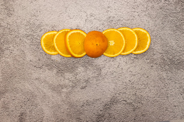 在灰色背景上切片新鲜的橙子图片下载
