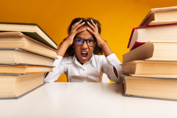 坐在书堆之间，黄色背景的女学生尖叫着抓着头图片下载