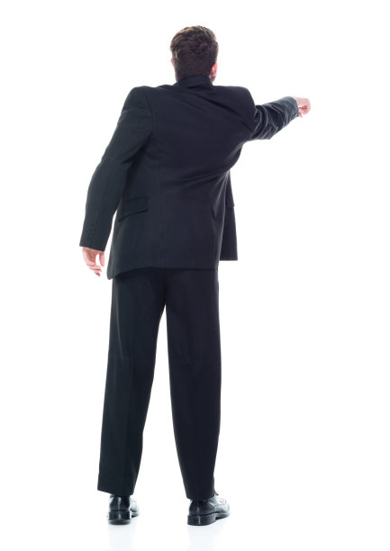 后视图/完整长度的20-29岁的成年美丽的高加索年轻女性/女经理/商人/商人站在白色背景穿着西装和触摸/显示触及谁是显示/指向图片下载