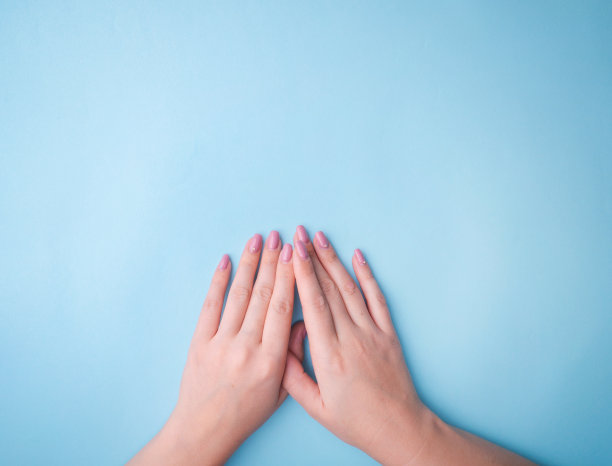 时尚艺术肖像女人与明亮的对比化妆。有创意的美丽照片女孩坐在桌子上对比鲜明的蓝色背景和彩色阴影。图片下载