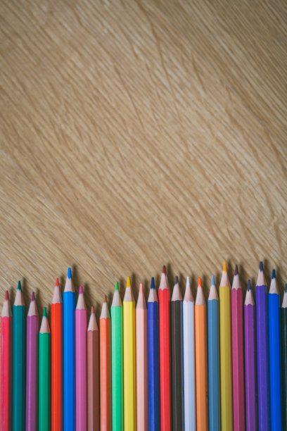 彩色铅笔在木制背景与复制空间。教育与返校理念。图片下载