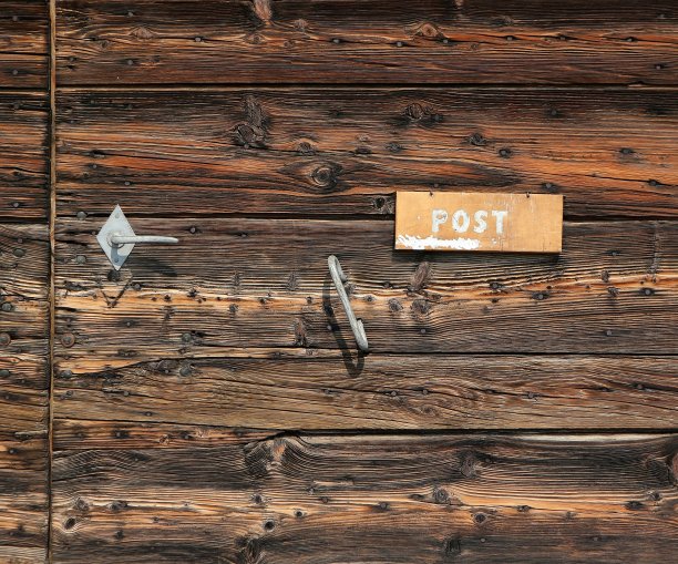 粗糙的木质前门上的旧的、刮花的信槽图片下载