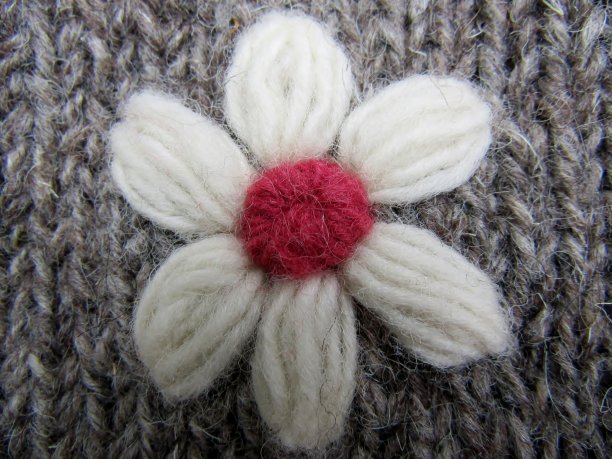 手工编织羊毛白色花在灰色背景特写图片下载