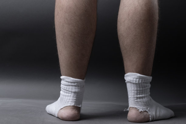 后面站着一双白袜子，灰色背景前有一个大洞图片下载