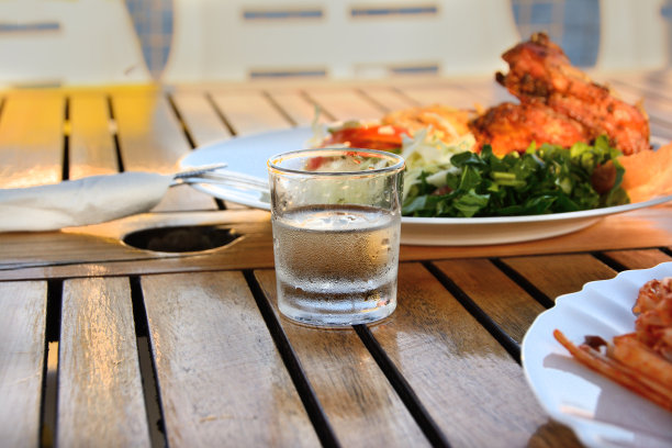 木桌上放着一杯冷伏特加和零食，特写图片下载