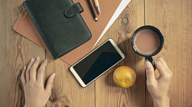 俯视图办公室文具与一杯果汁和桔子。图片下载