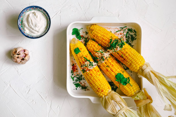 三个烤玉米棒，淋上酱汁图片下载