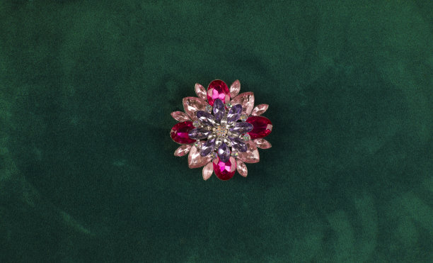优雅的珍贵胸针上的绿色背景图片下载
