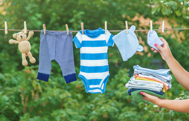 洗宝宝的衣服。亚麻在新鲜空气中会变干。有选择性的重点。图片下载