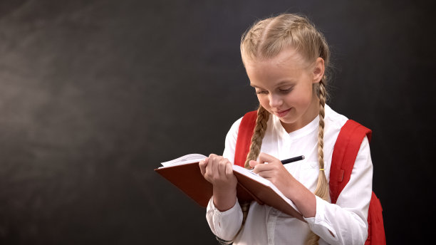 爱做梦的小女生在笔记本上写字，在黑板上做作业图片下载