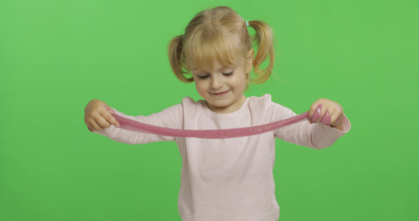 孩子玩手工制作的玩具黏液。孩子有乐趣，使粉红色的粘液图片下载