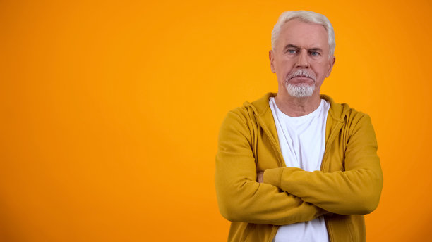 不高兴的退休人员抱着双臂思考问题，不赞成和拒绝图片下载