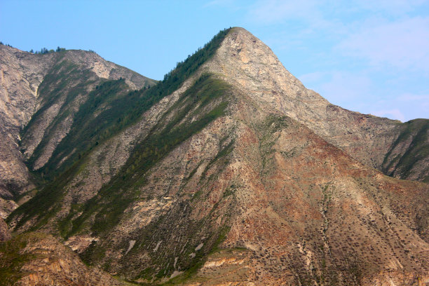 在蓝天的映衬下，巨大的山脉覆盖着天鹅绒般的绿色植物图片下载