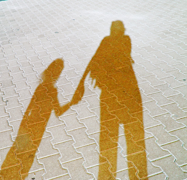 妈妈和小女孩抱着扎鲁克过马路时的长长的影子，图片下载