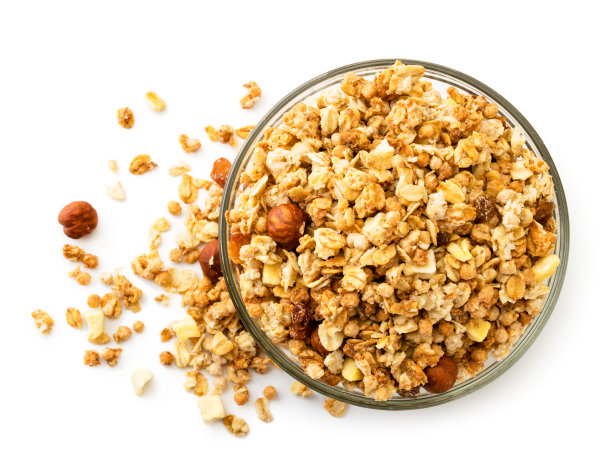 格兰诺拉麦片从玻璃盘子里洒在了桌上。山顶的景色。图片下载