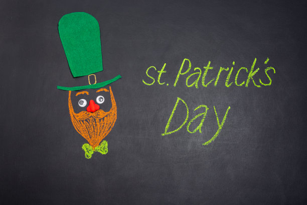 滑稽的小精灵脸和用绿色粉笔在黑板上的题词:圣帕特里克节。图片下载