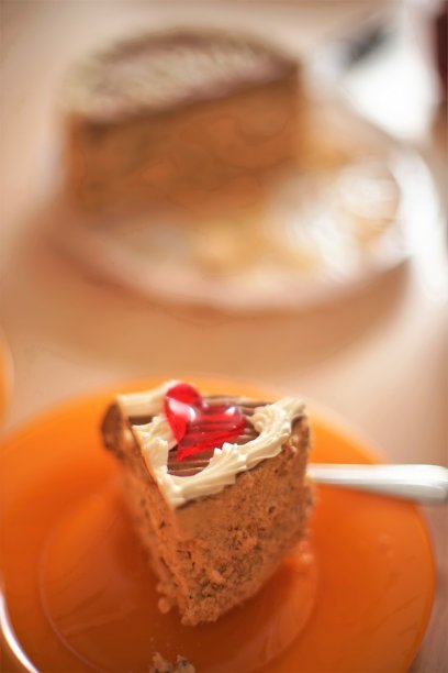 橙色的盘子里放着一块基辅蛋糕，用叉子叉着图片下载