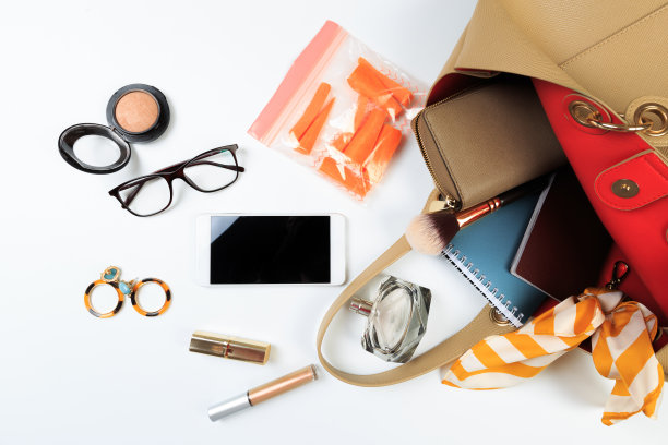 时尚概念:平铺的棕色皮质女包打开，太阳镜和智能手机在白色背景。图片下载