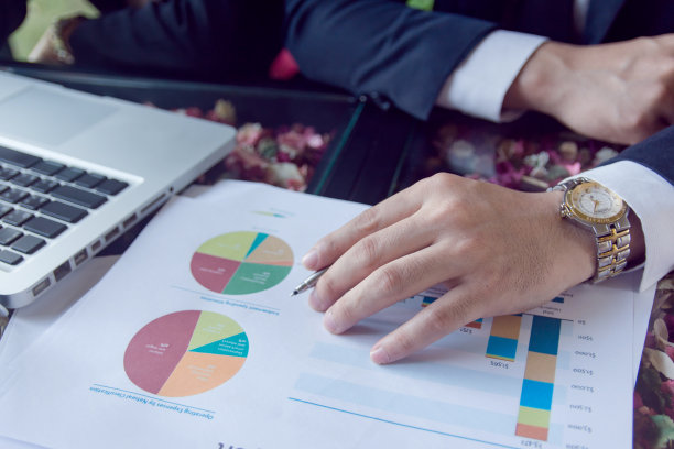 商人的手用钢笔指着总结报告和使用笔记本电脑图片下载