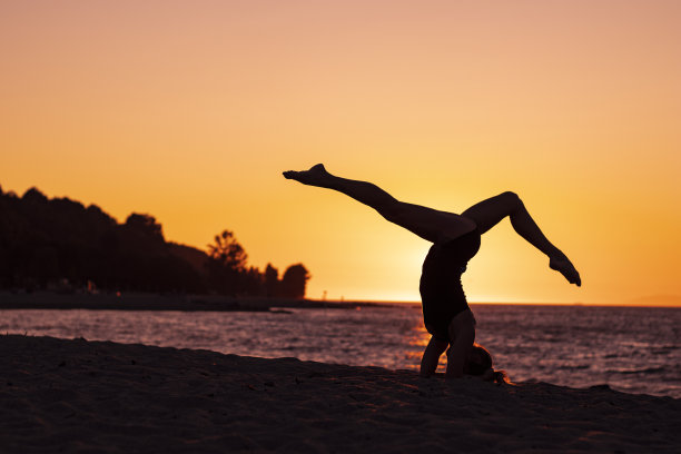 女人瑜伽放松日落在海滩上图片下载